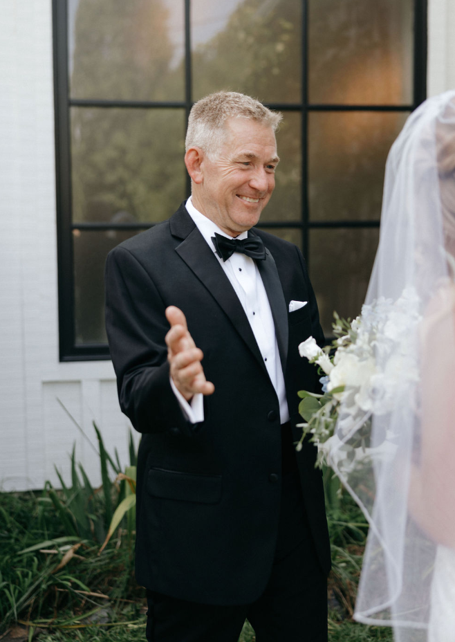 Father looking at bride on wedding day